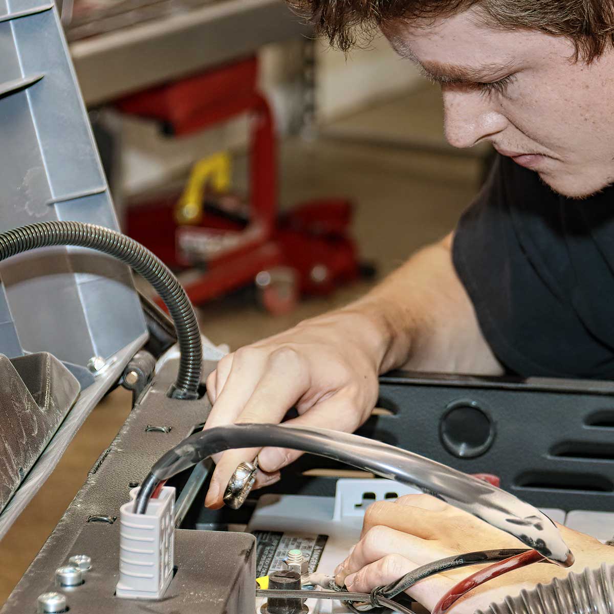 Technician testing floor scrubber batteries
